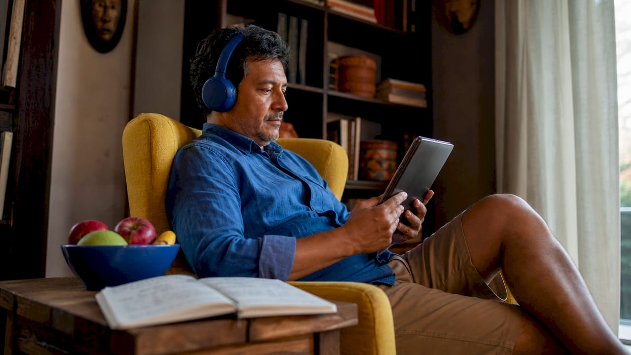 Man practicing Spanish listening with tablet