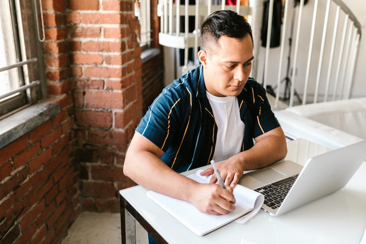 a person taking down notes based on his learnings